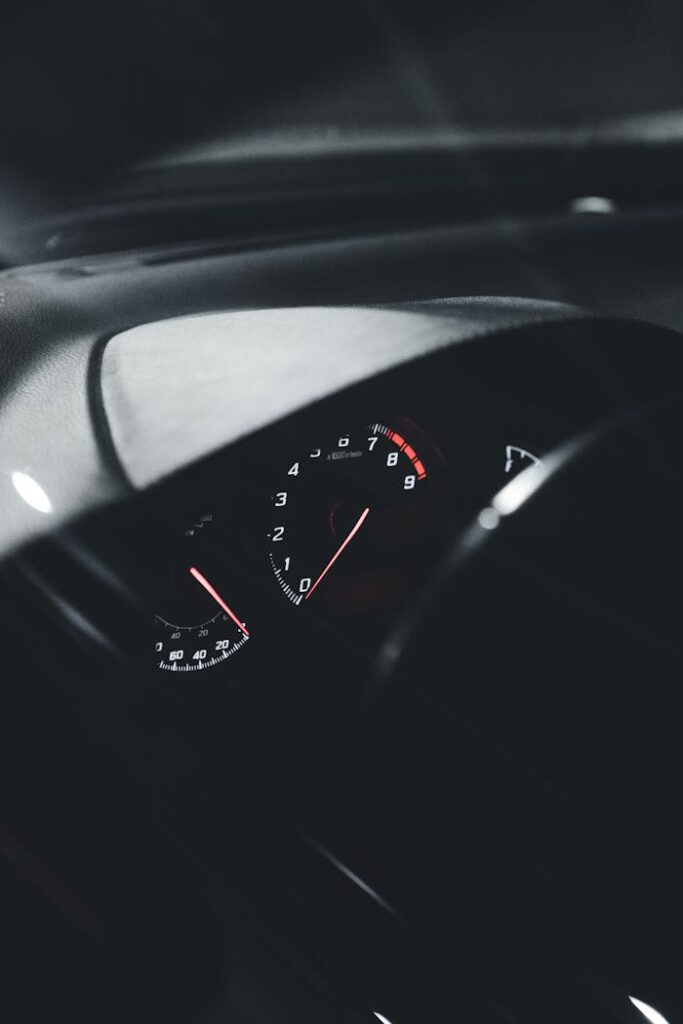 Close-up view of an illuminated car speedometer at night, showcasing sleek interior design.