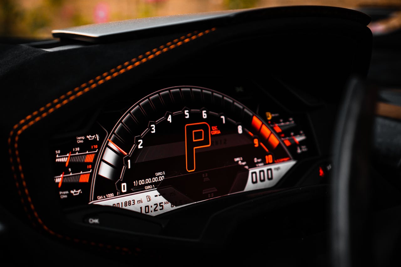 Close-up of a luxury car dashboard with digital speedometer and odometer.